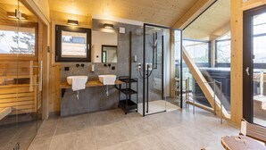 A modern bathroom with wooden beams, a glass shower, and a wooden bench. - Superior Chalet III with Sauna & Hot Tub (Turrach)
