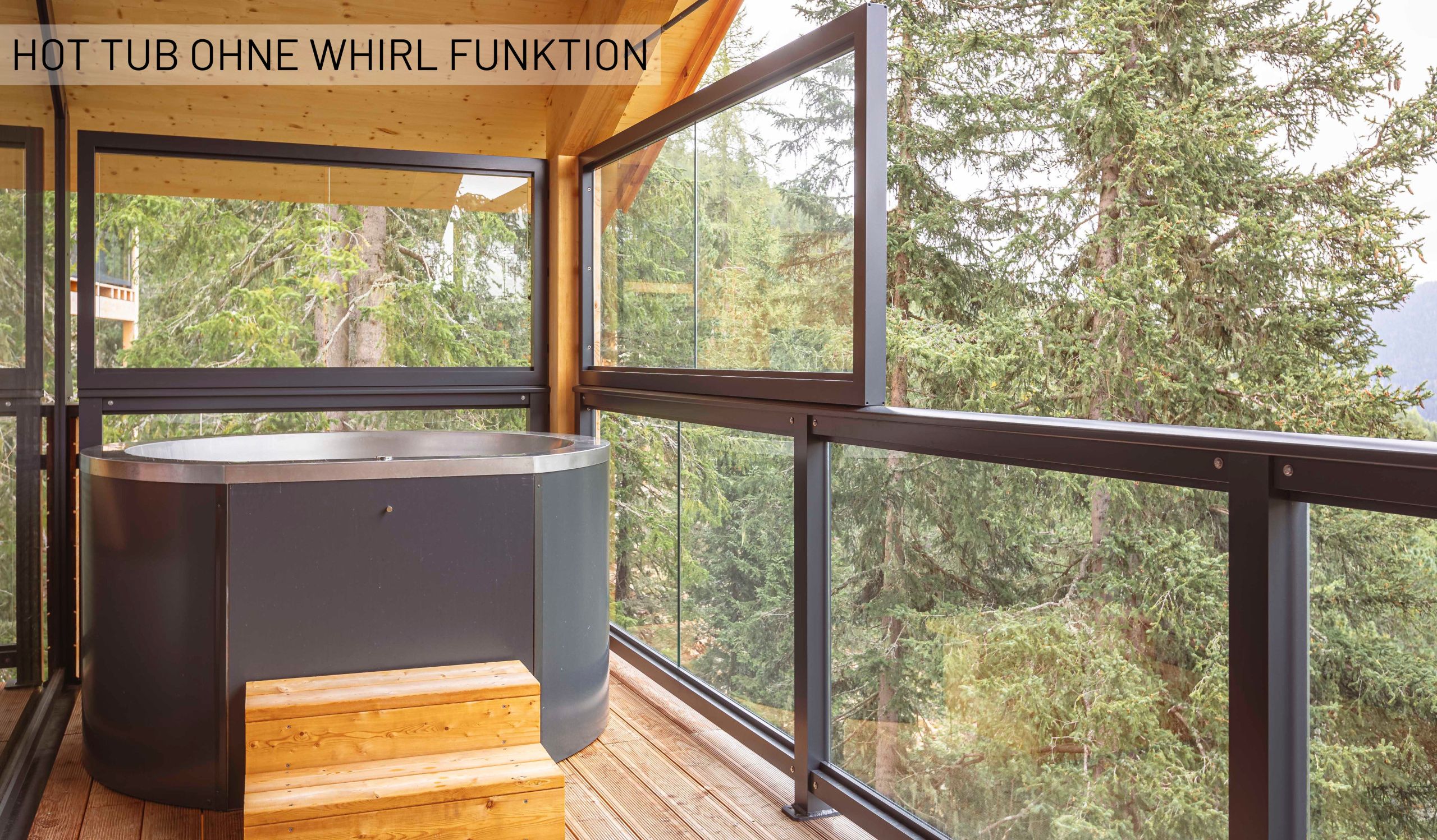 A hot tub without a whirl function, set in a modern wooden deck with large windows overlooking a forest.