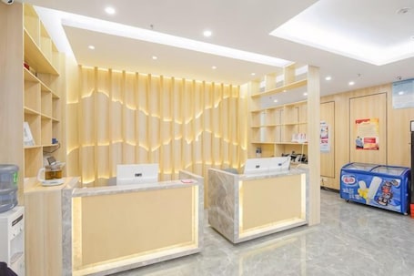 A reception area with two marble counters, a water dispenser, and a blue vending machine.