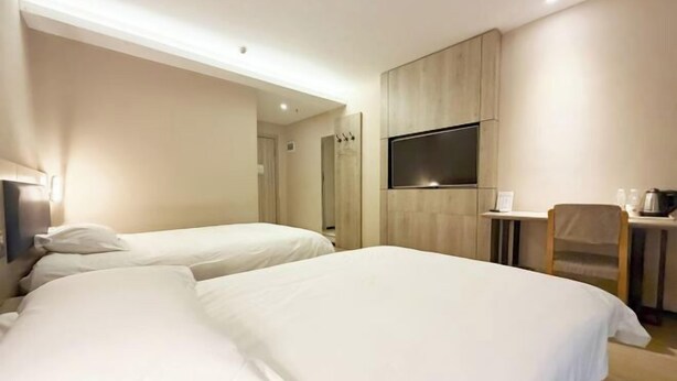 A hotel room with two beds, a TV, a desk, and a chair. - Meet Maple Hotel (Shijiazhuang)