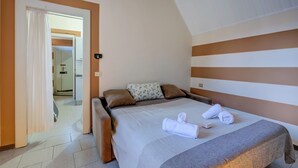 Ein Hotelzimmer mit einem Bett und einem durch eine geöffnete Tür einsehbaren Badezimmer sowie einer Duschkabine.