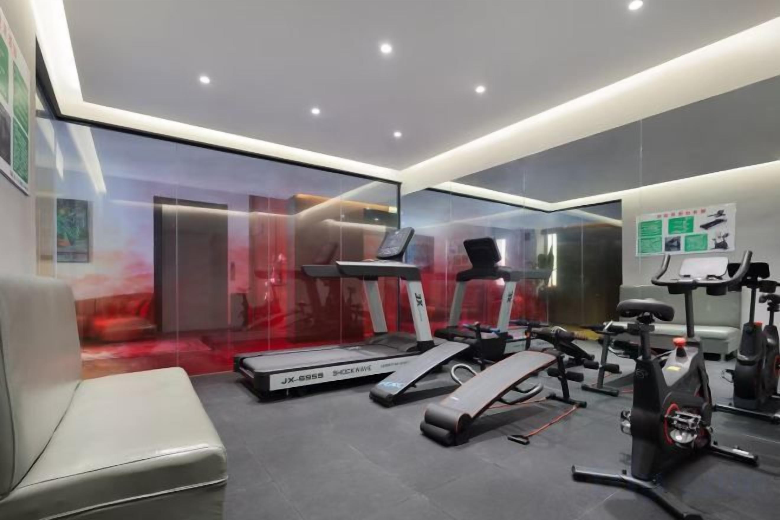 Un gimnasio moderno con cintas de correr, una bicicleta estática y una banca.