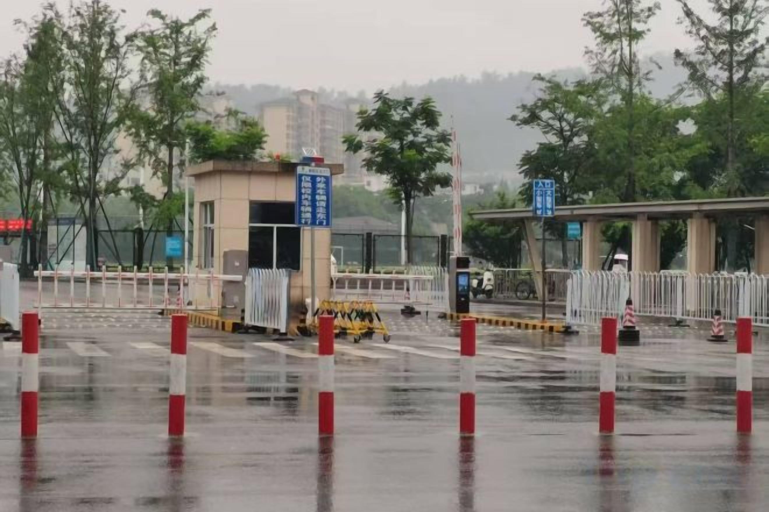 Un espace de stationnement humide avec un guichet pour les tickets, un passage piéton et une allée couverte.