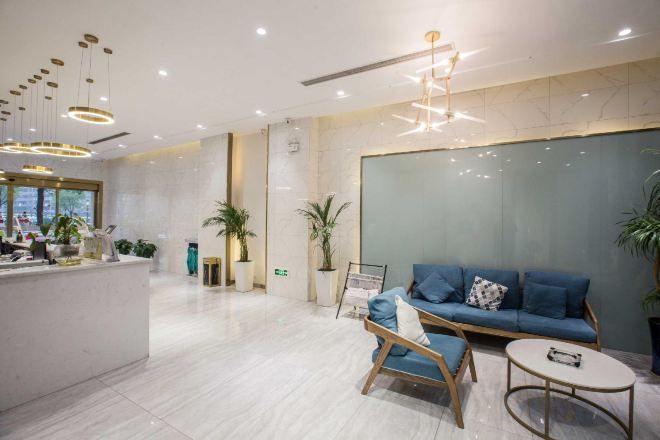 A modern reception area with a reception desk, seating area, and a large window.