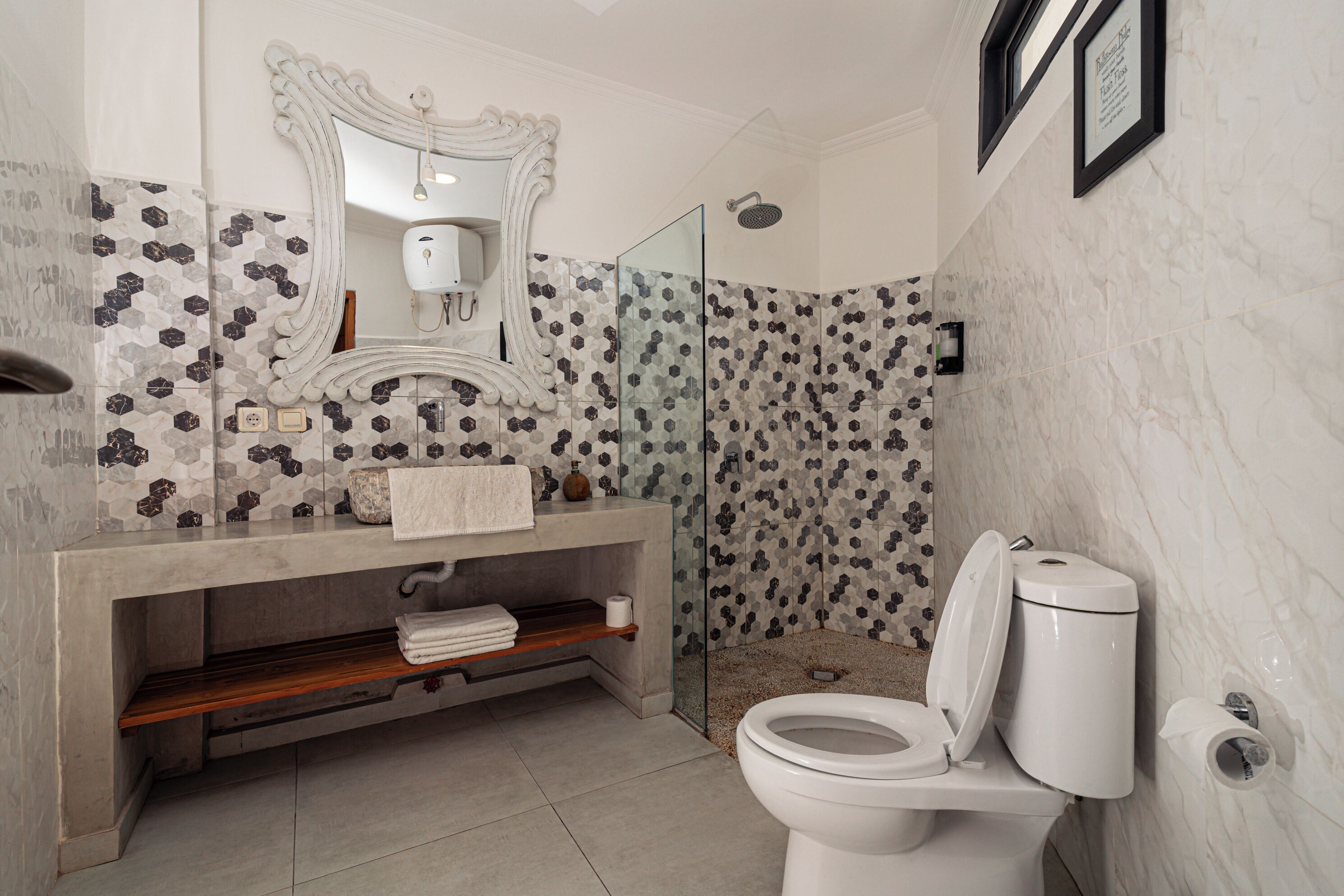 Un baño con ducha, inodoro, tocador y espejo.