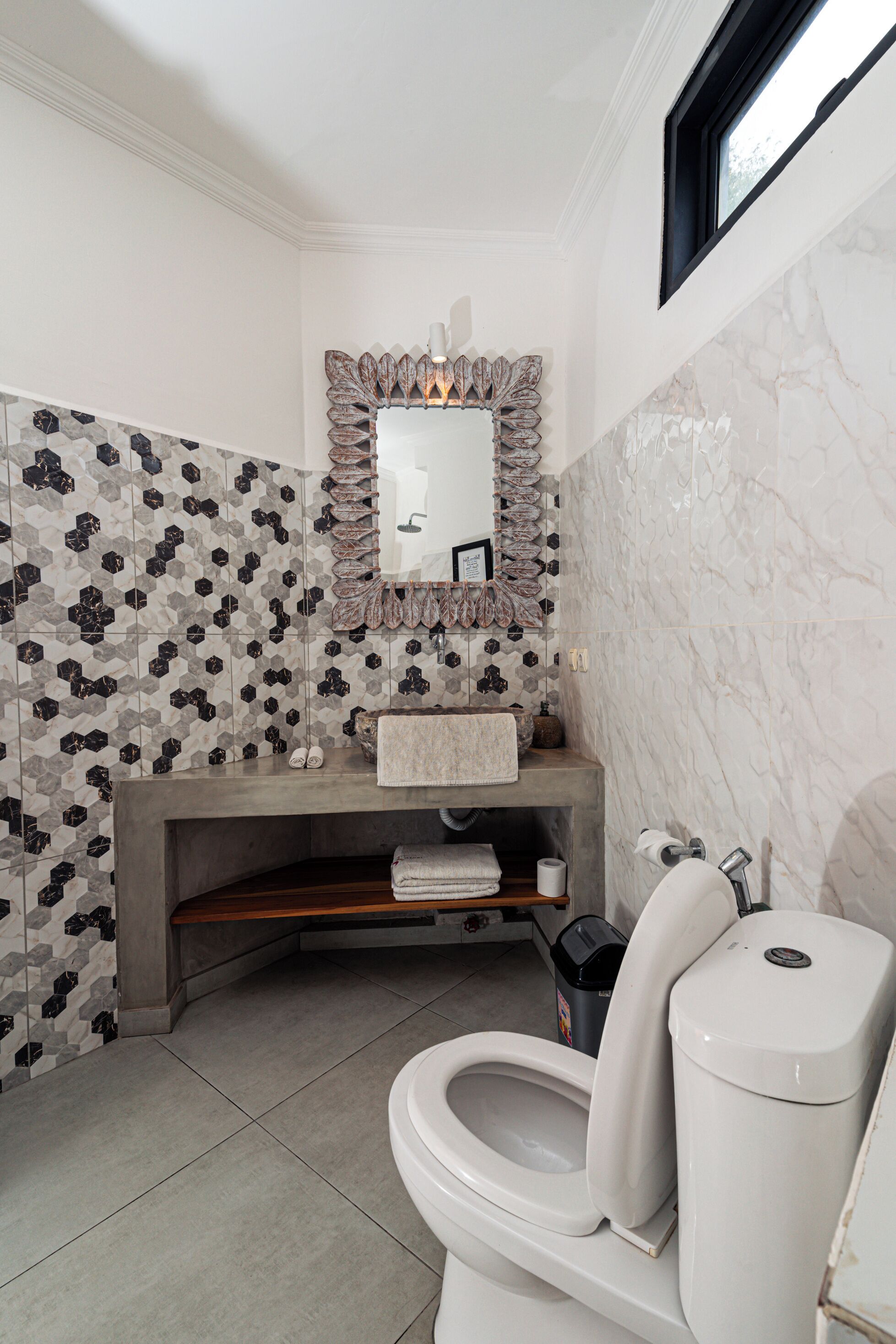 Ein Badezimmer mit Marmorwaschbecken, Toilette und Duschbereich.