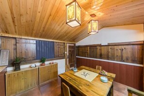 A wooden interior with a dining table, chairs, and a ceiling with hanging lanterns. - Painting Base in Yun Shui Trackway (Nanjing County)