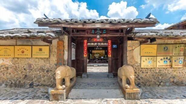 A traditional building entrance with stone walls, a tiled roof, and two stone elephants at the entrance. - Painting Base in Yun Shui Trackway (Nanjing County)