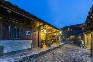A stone-paved courtyard with wooden buildings, a staircase, and a well-lit interior. - Painting Base in Yun Shui Trackway (Nanjing County)