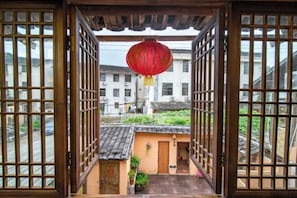 A traditional Japanese gate with a red lantern hanging above, leading to a small courtyard with a tiled roof and a potted plant. - Painting Base in Yun Shui Trackway (Nanjing County)