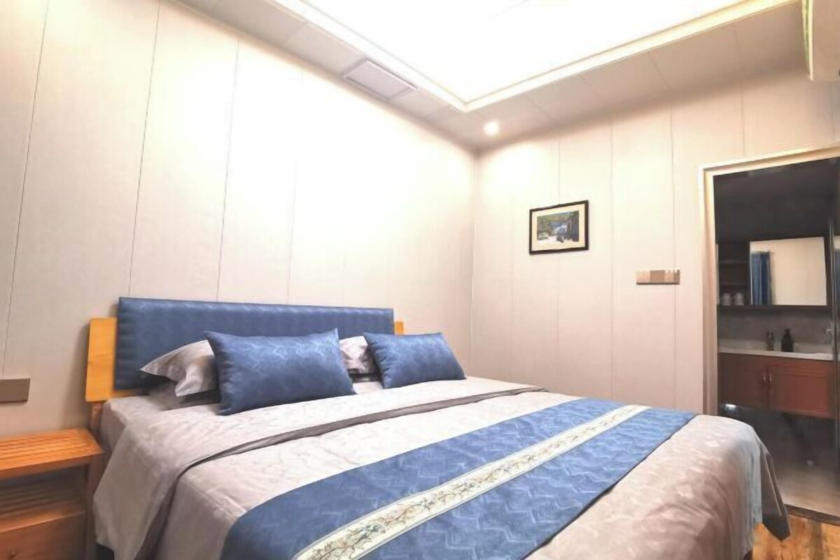 A bedroom with a bed, a bedside table, a wardrobe, and a skylight.