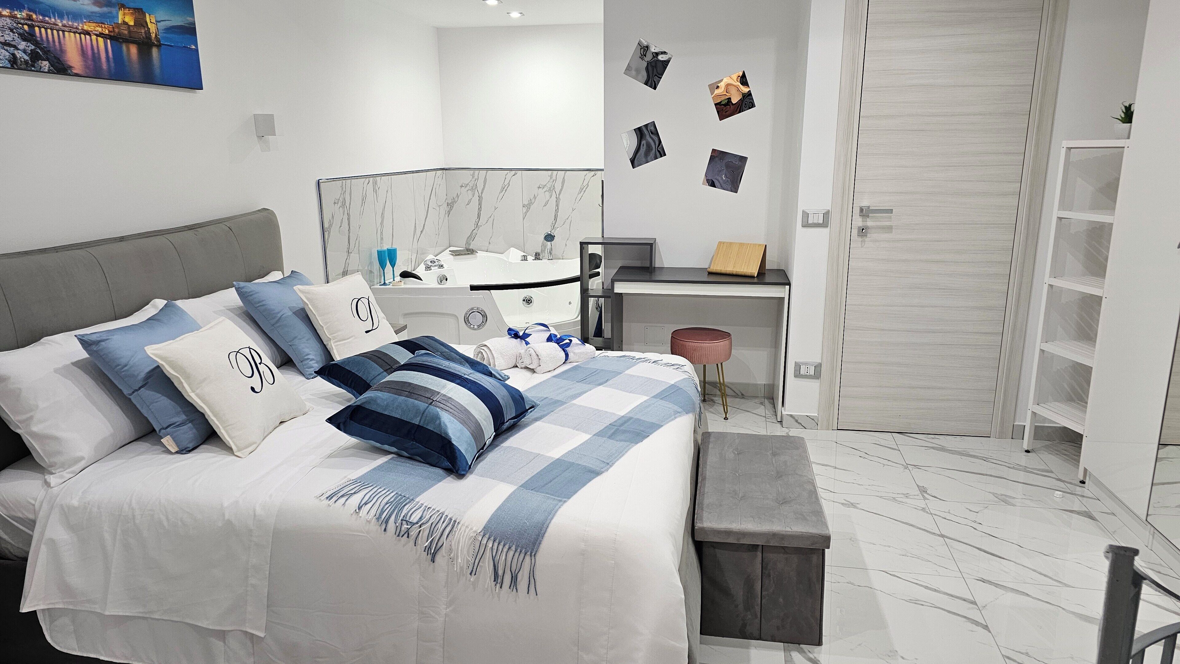 Un dormitorio moderno con una cama, un escritorio y un baño.