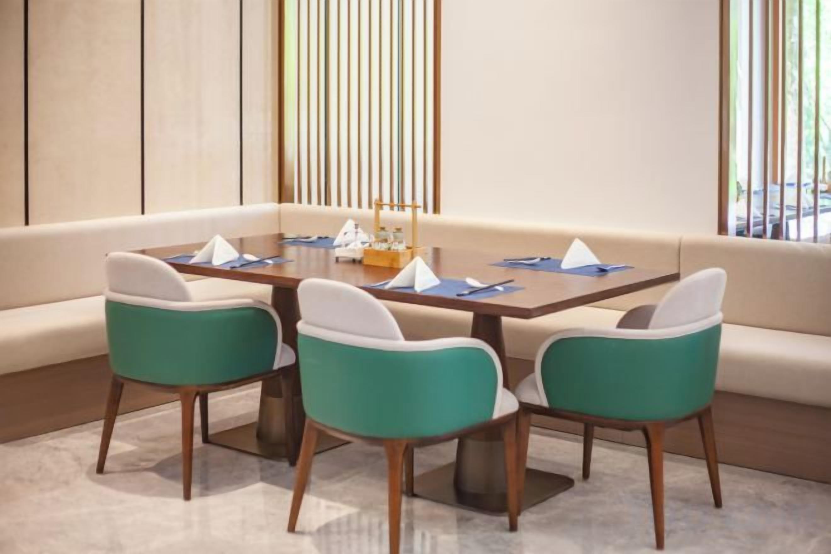 A dining area with a table, four chairs, and a sofa.
