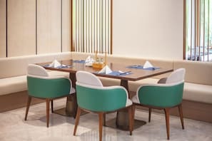 Un comedor con mesa, cuatro sillas y sofá.