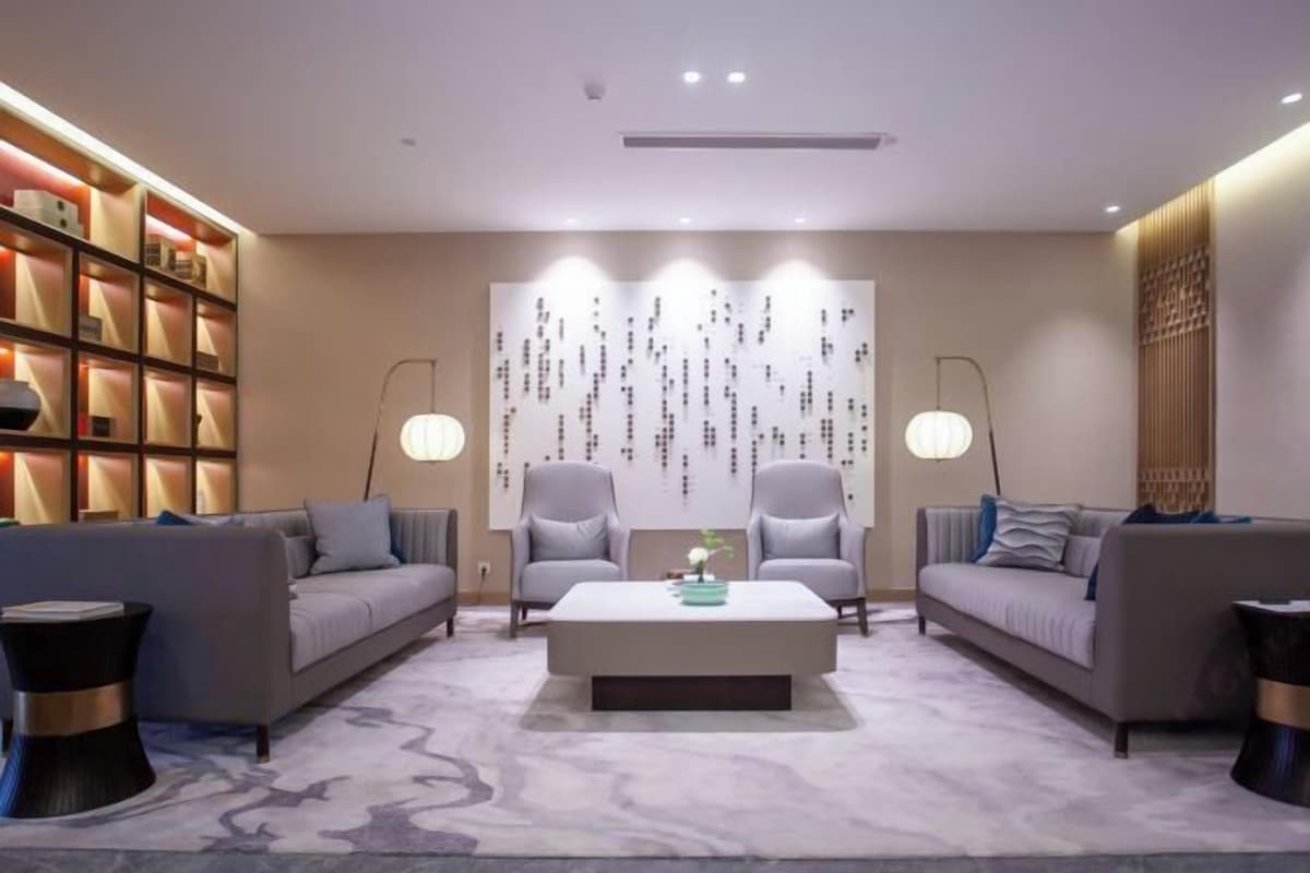 A modern living room with a sofa set, a coffee table, and a decorative wall.
