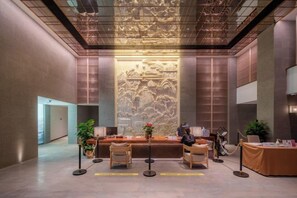 A lobby with a reception desk, seating area, and a large decorative wall. - Shenxianju Narada Resort (Xianju)