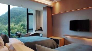 Une chambre d’hôtel moderne équipée de deux lits, d’un bureau et d’une télévision.
