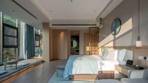 Una habitación de hotel moderna con una cama grande, un escritorio y vistas al exterior.