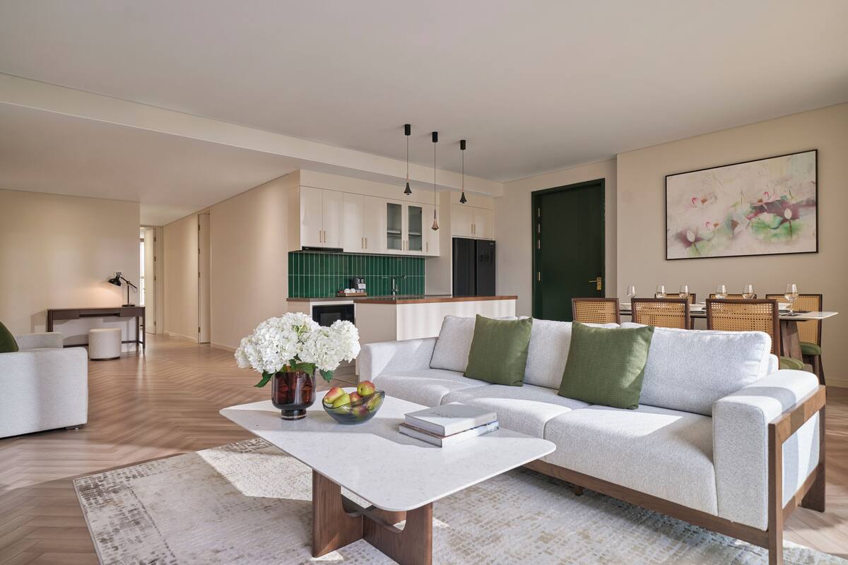 Una sala moderna con un sofá, una mesa de centro y una zona de comedor con sillas y una mesa.