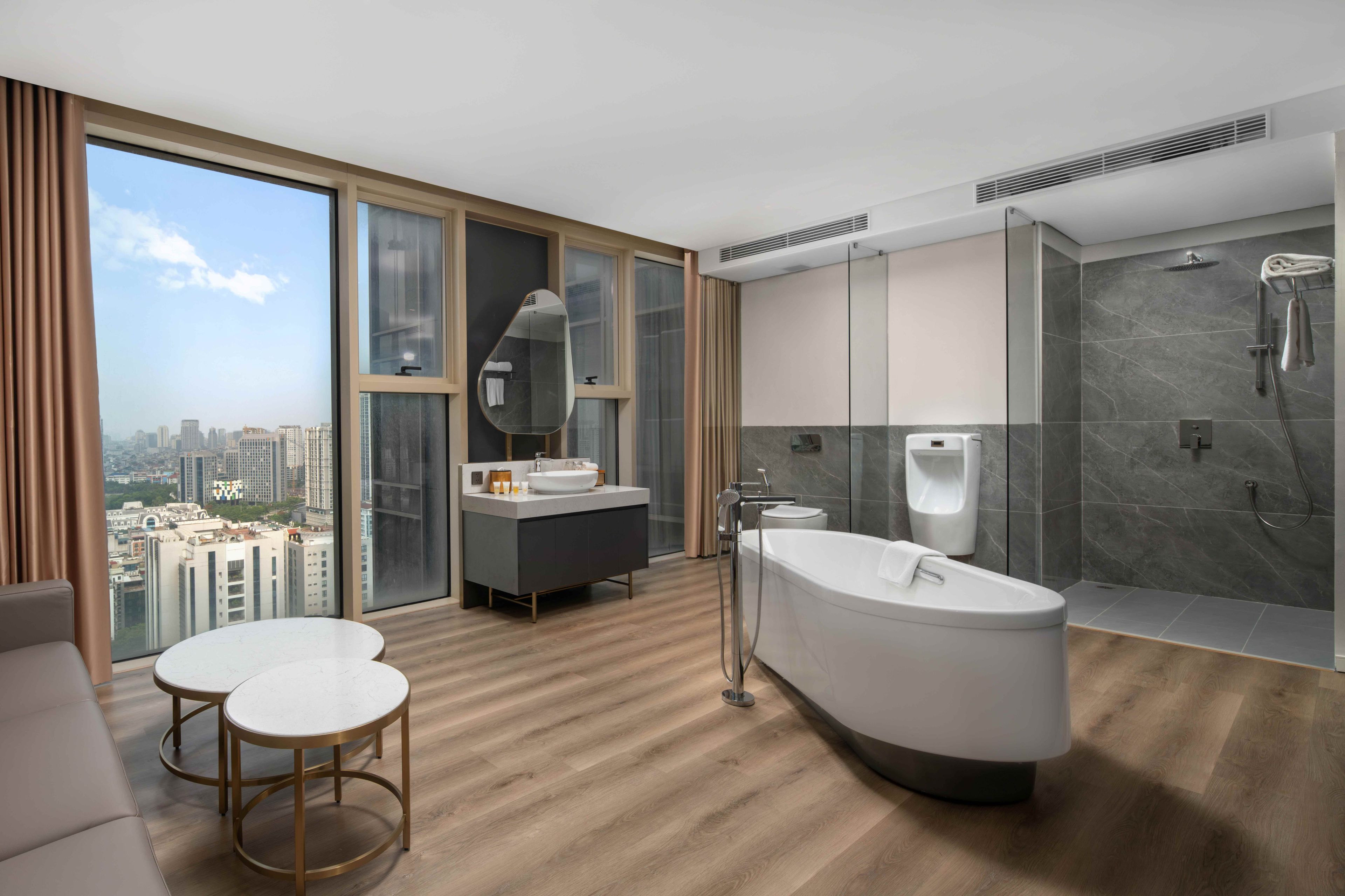 A modern bathroom with a large bathtub, a separate shower area, and a vanity with a mirror.