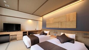 Een moderne hotelkamer met twee bedden, een bureau, een flatscreen televisie en een kunstwerk aan de muur.