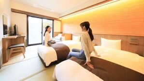 Een hotelkamer met twee bedden, een bureau en een stoel.