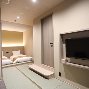 A hotel room with two beds, a television, and a sliding door. - Miyawaka Torano Yu (Miyawaka)