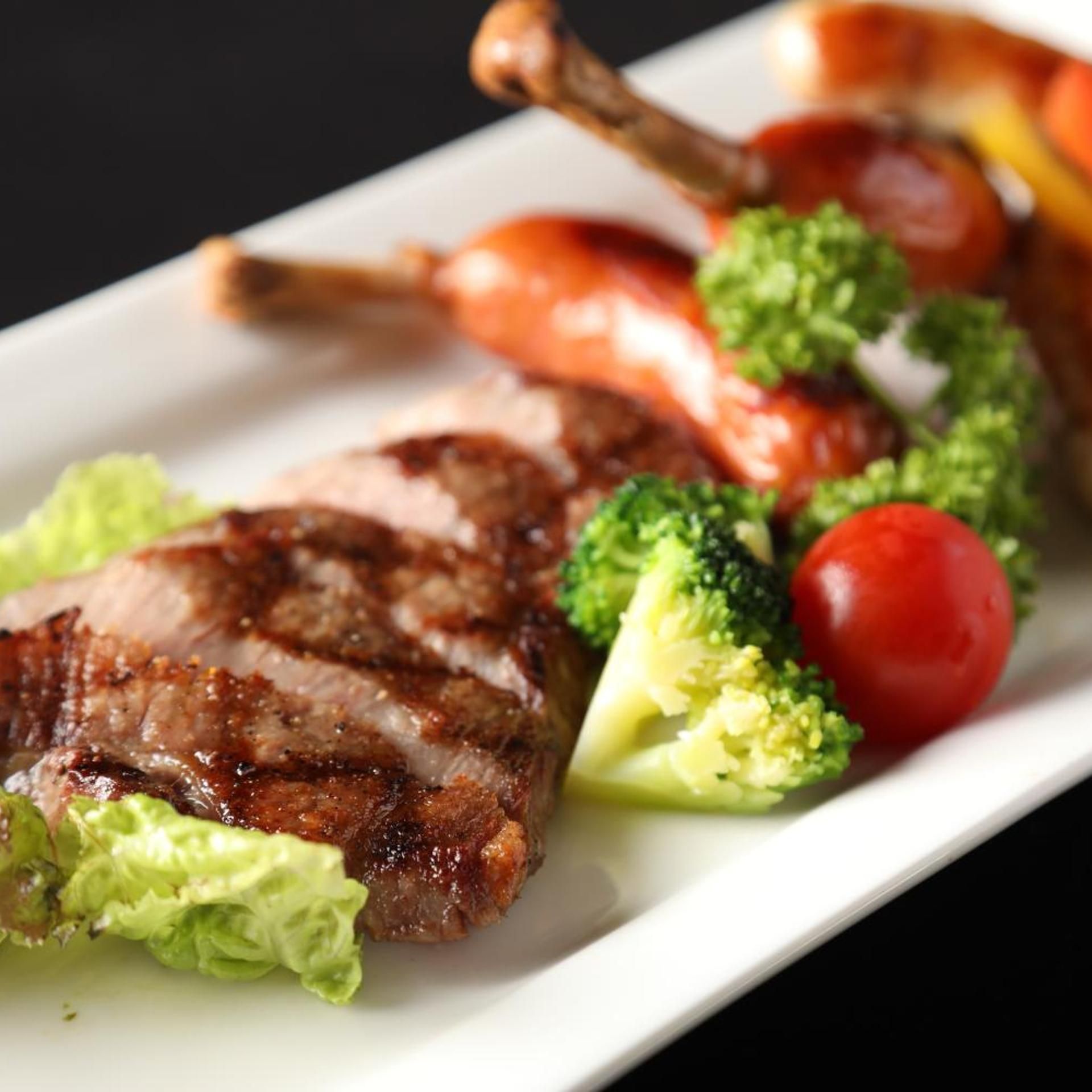 Prato com carne grelhada, brócolis e tomate cereja.