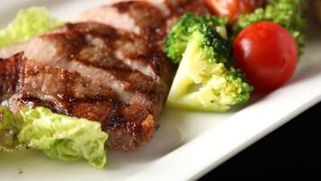 Prato com carne grelhada, brócolis e tomate cereja.