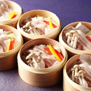 Varias vaporeras de bambú con ingredientes frescos.