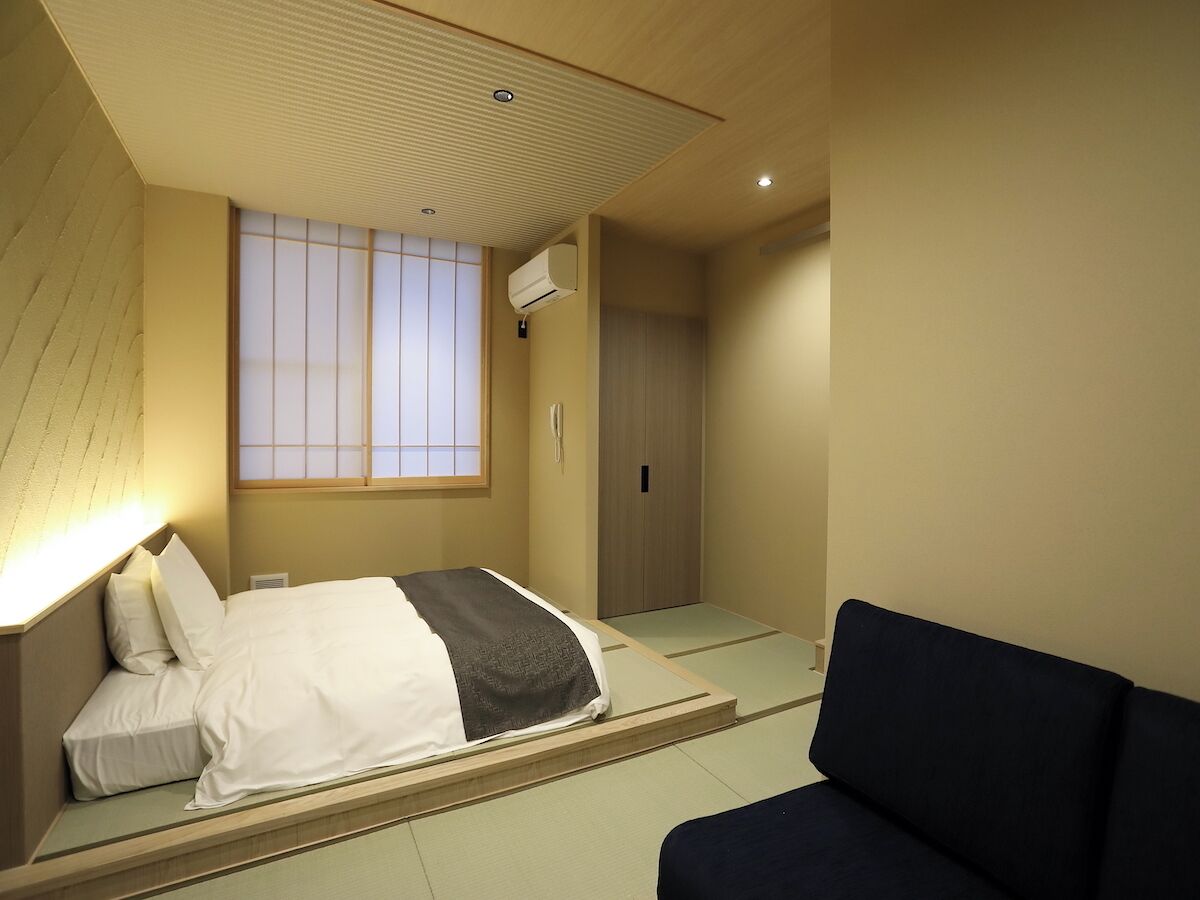 Hotelkamer met een bed, een sofa, een schuifdeur en een raam met uitzicht.