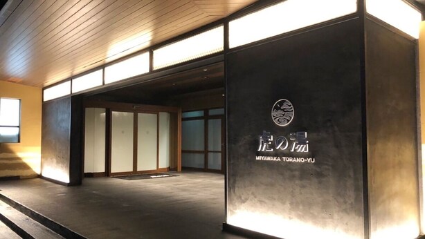 A building entrance with a sign reading 'MIYAWA KAI TORANO-YU' and a wooden ceiling. - Miyawaka Torano Yu (Miyawaka)