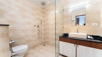 Un baño moderno con cabina de ducha de vidrio, inodoro blanco y tocador con espejo.