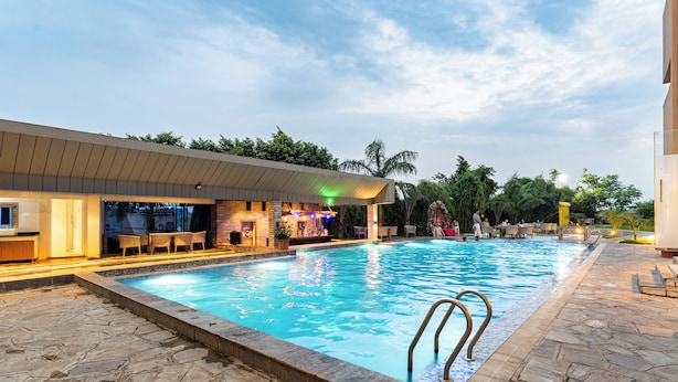 Une piscine avec un bar et des espaces de détente en plein air.