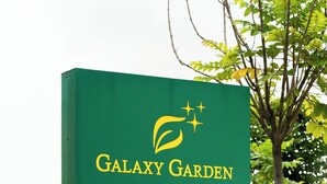 Une pancarte indique les équipements disponibles au Galaxy Garden, notamment des salles de réception, des restaurants, un espace de restauration privatif, un jardin extérieur, une piscine, une salle de sport, un centre de bien-être/spa, une salle de conférence, des chambres et un restaurant-bar à concept original.