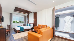 A hotel room with a bed, a sofa, a desk, and a walk-in closet. - Galaxy Garden Resort (Bharatpur)