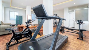 Une salle de sport à domicile équipée d’un tapis de course, d’un vélo d’appartement et d’un banc de musculation.