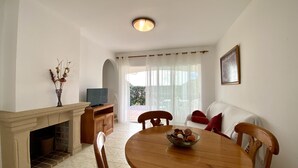 Ein Essbereich mit Holztisch, Stühlen, einem Fernseher und einem Kamin.