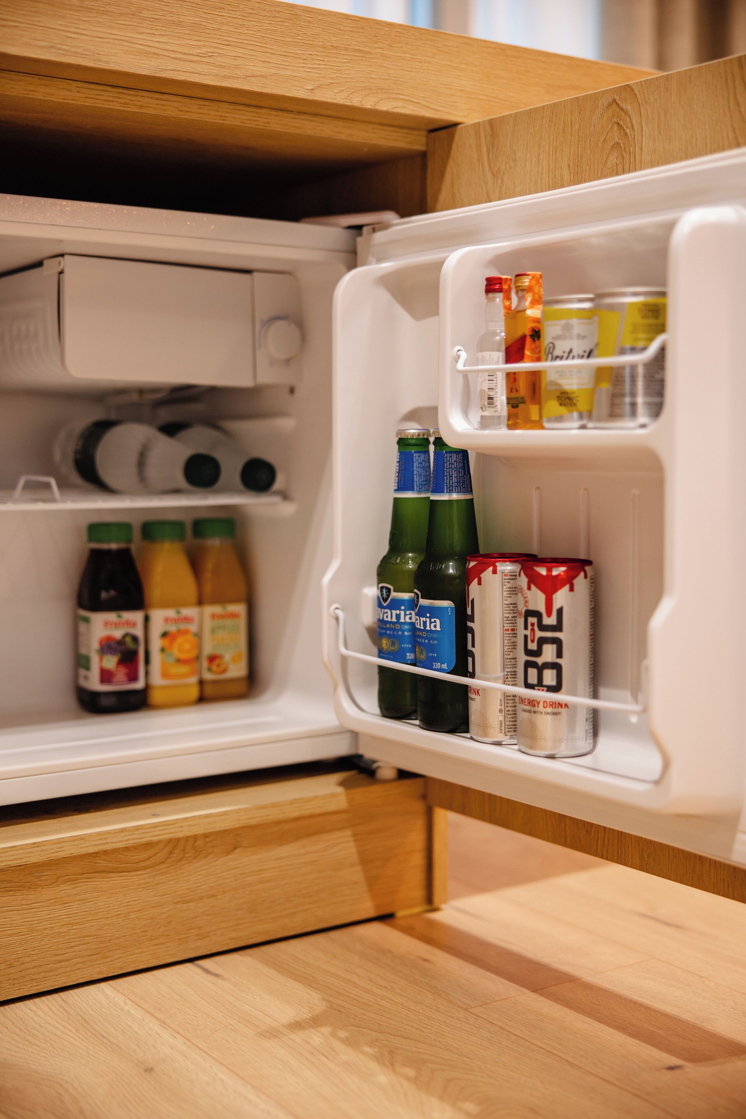 A refrigerator with beverages and a can of energy drink.