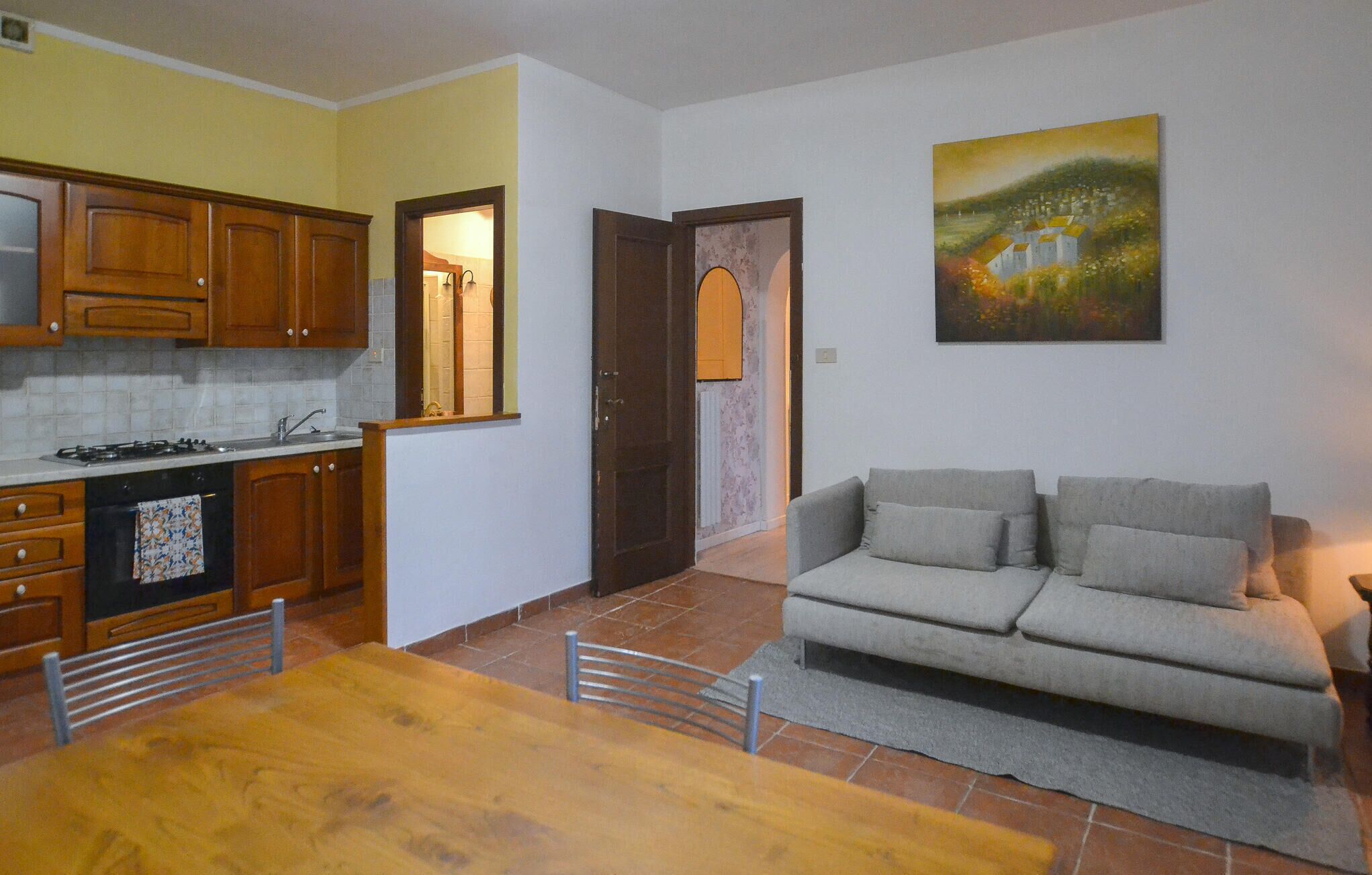 A compact living space with a kitchen, dining area, and a sofa.