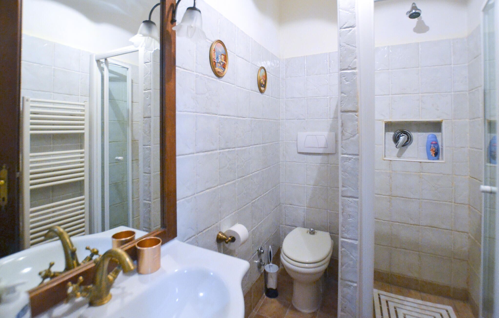 A bathroom with a sink, toilet, and shower.