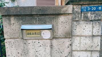 A stone wall with a mailbox and a street sign.