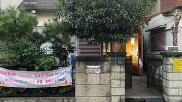 A gated entrance to a building with a banner advertising a guest house.