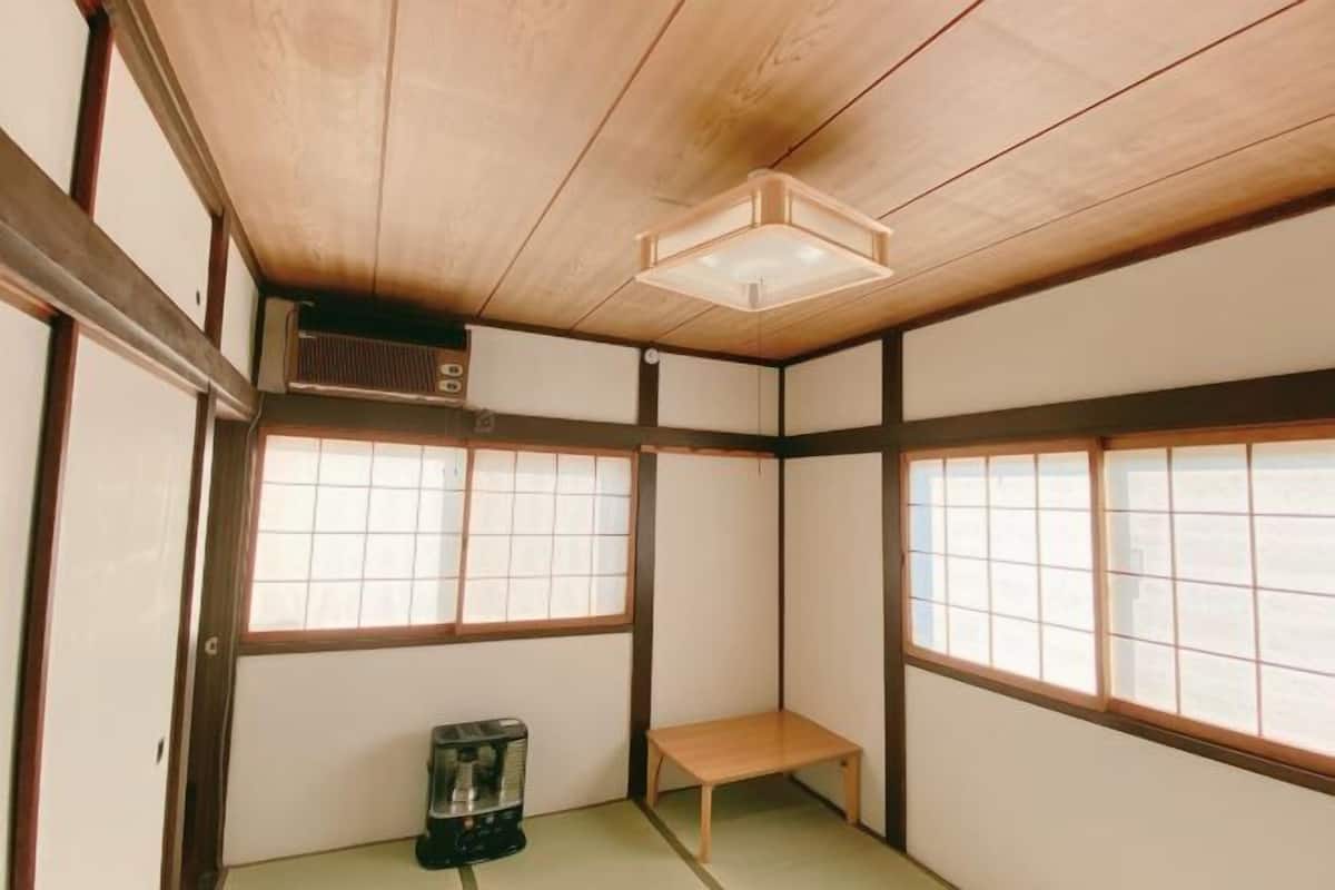 Et traditionelt japansk rum med tatamimåtter, skydedøre og et lille bord.