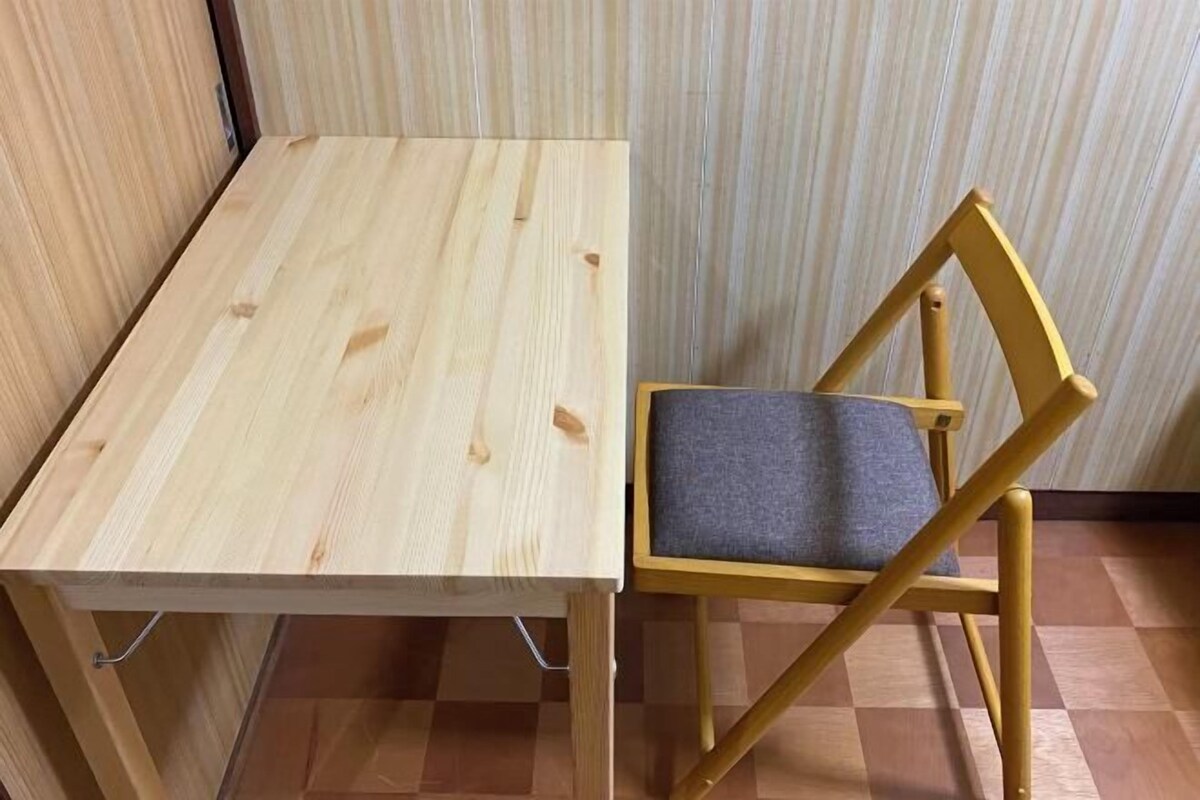 Une table en bois avec une chaise dotée d’un siège rembourré.