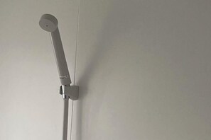 Un pommeau de douche fixé au mur.