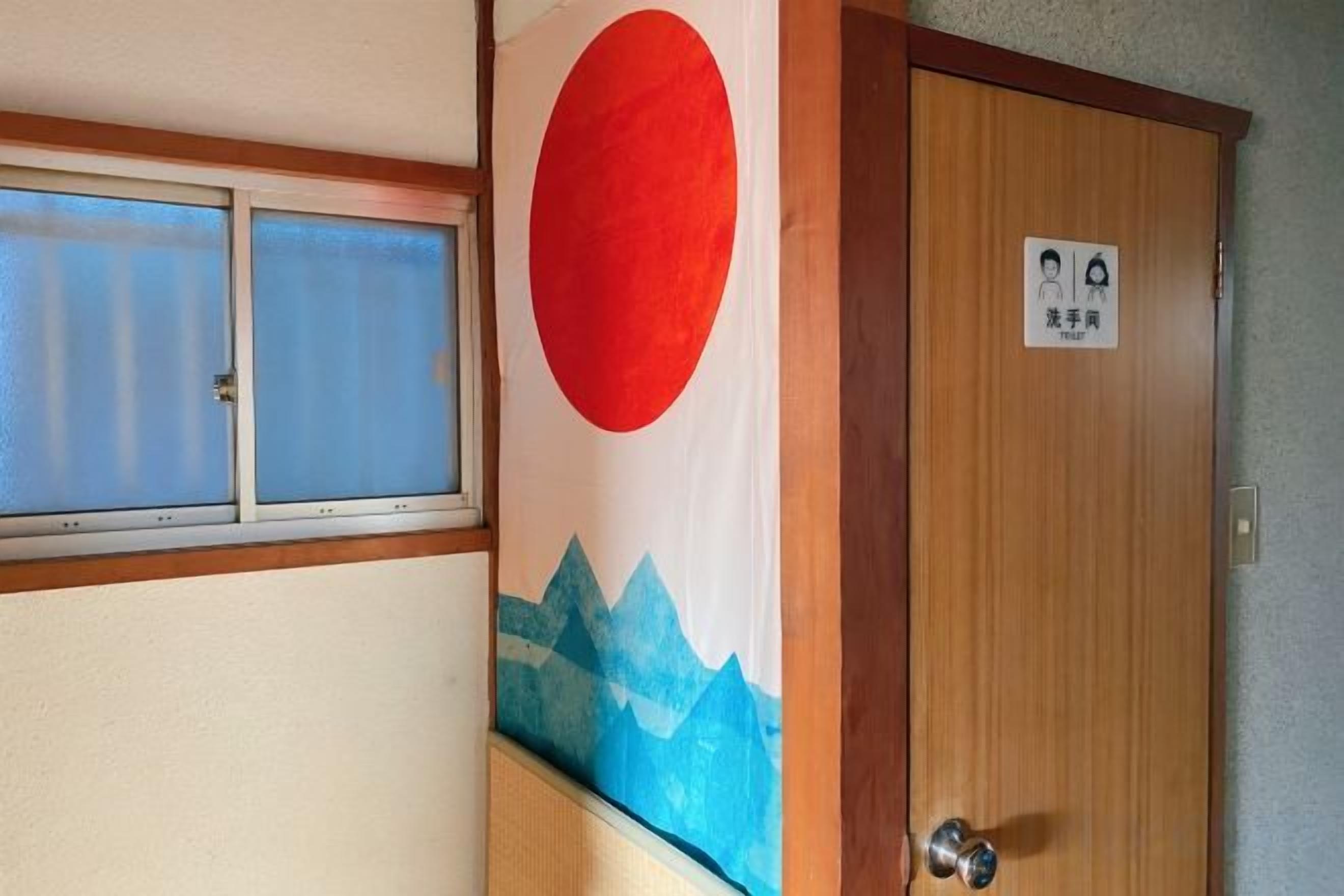 Una puerta de madera con un ventanal y un adorno circular rojo.