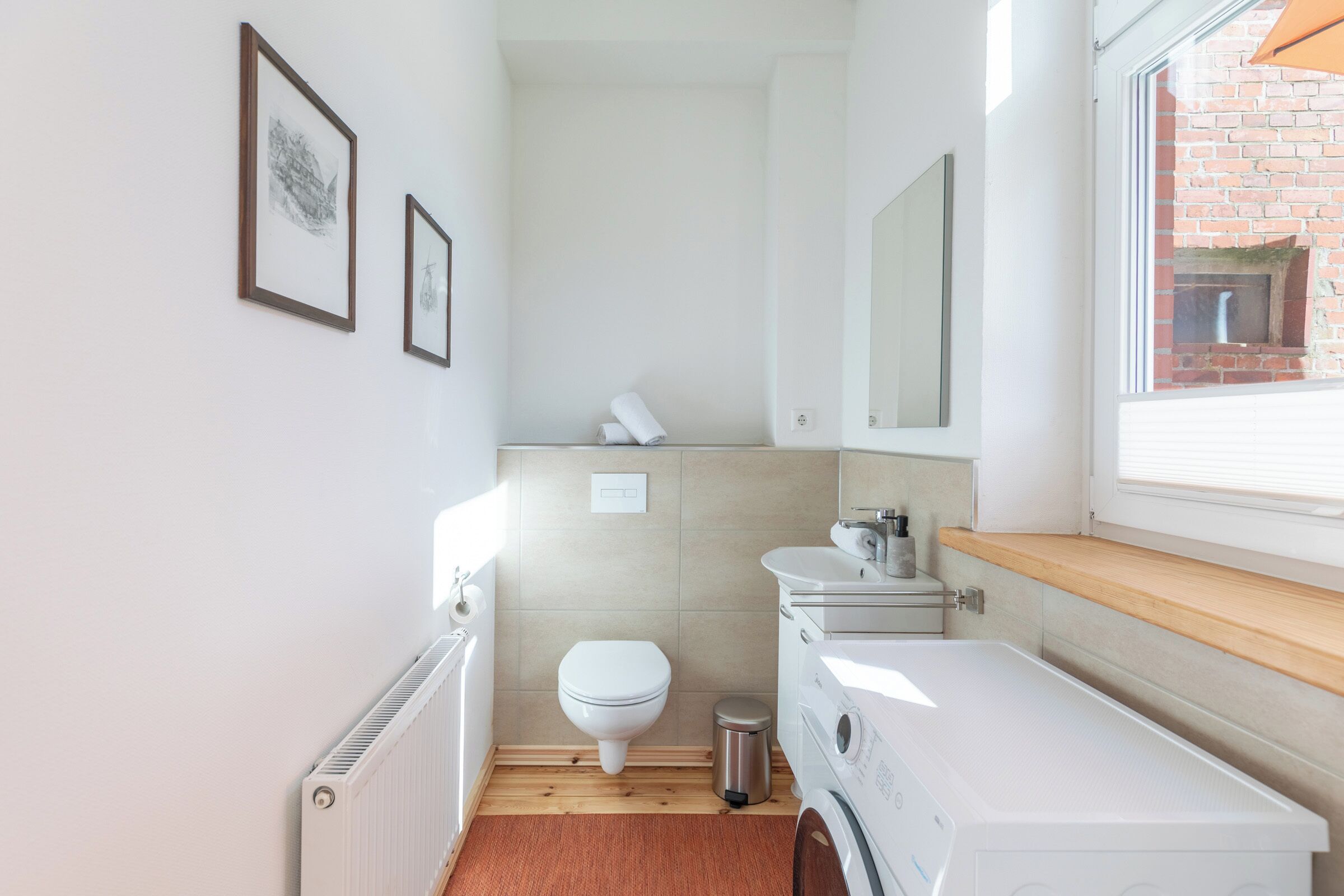 Ein kleines Badezimmer mit Toilette, Waschbecken und Waschmaschine.