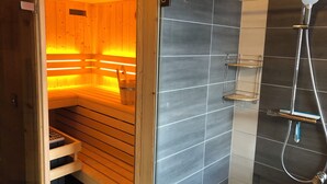 Una sauna con bancos de madera y cabina de ducha de vidrio.