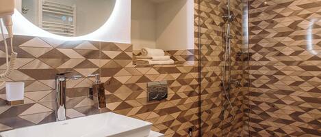 A modern bathroom with a white sink, a mirror, a toilet, and a shower.